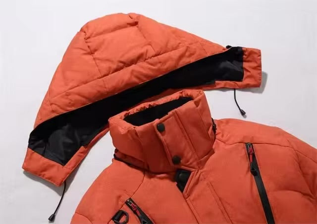 Orange vinterjakke med aftagelig hætte, lynlåslommer og høj krave. Perfekt til udendørs aktiviteter i koldt vejr. Varm og stilfuld jakke.
