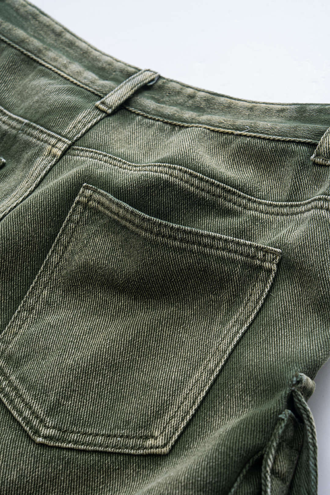 Grønne denimjeans med baglomme, tæt på. Slidstærkt stof, klassisk design. Perfekt til casual mode og hverdagsbrug.