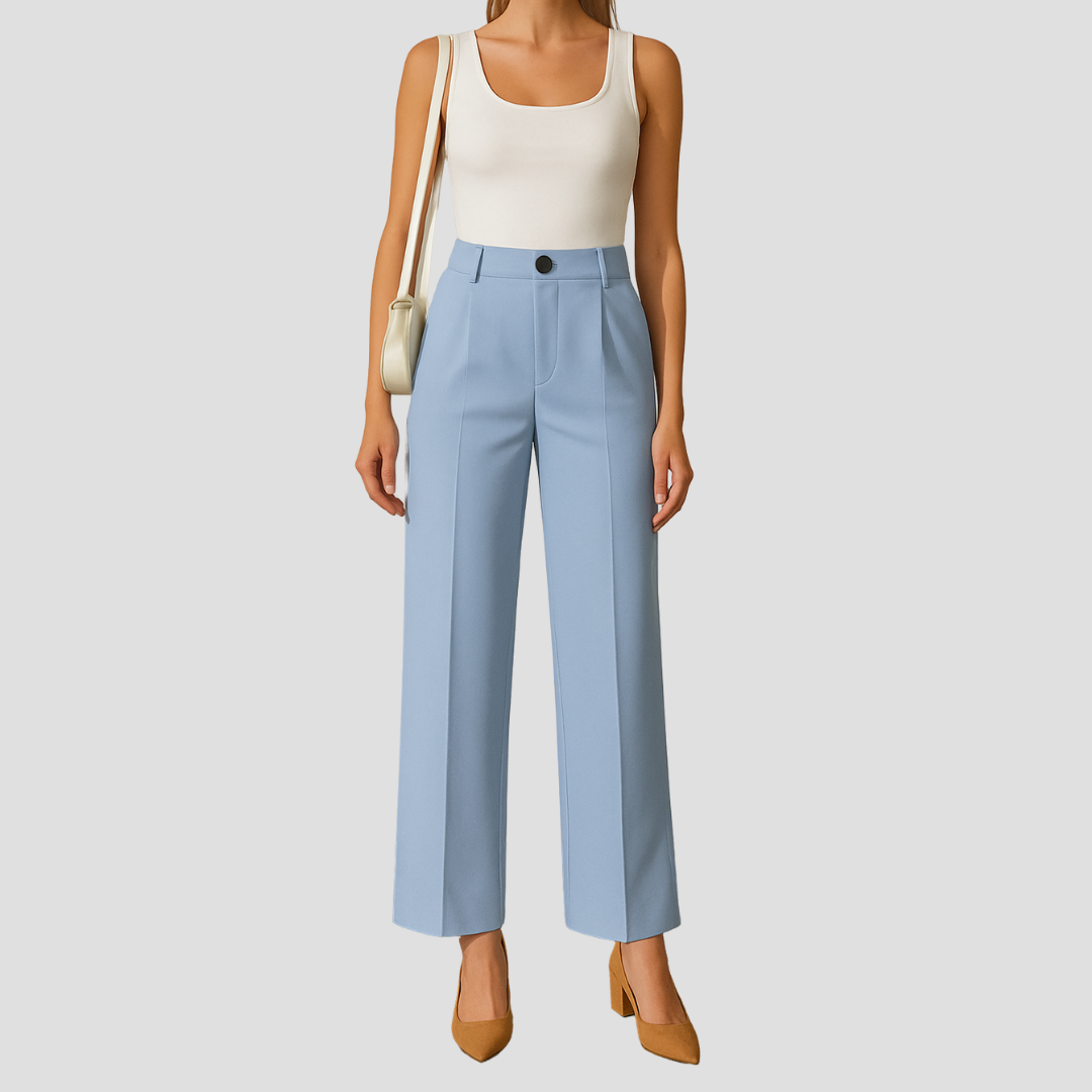 Kvinde iført hvid tanktop, lyseblå bukser og brune sko, bærer en beige skuldertaske. Moderne mode, stilfuldt outfit, casual look.