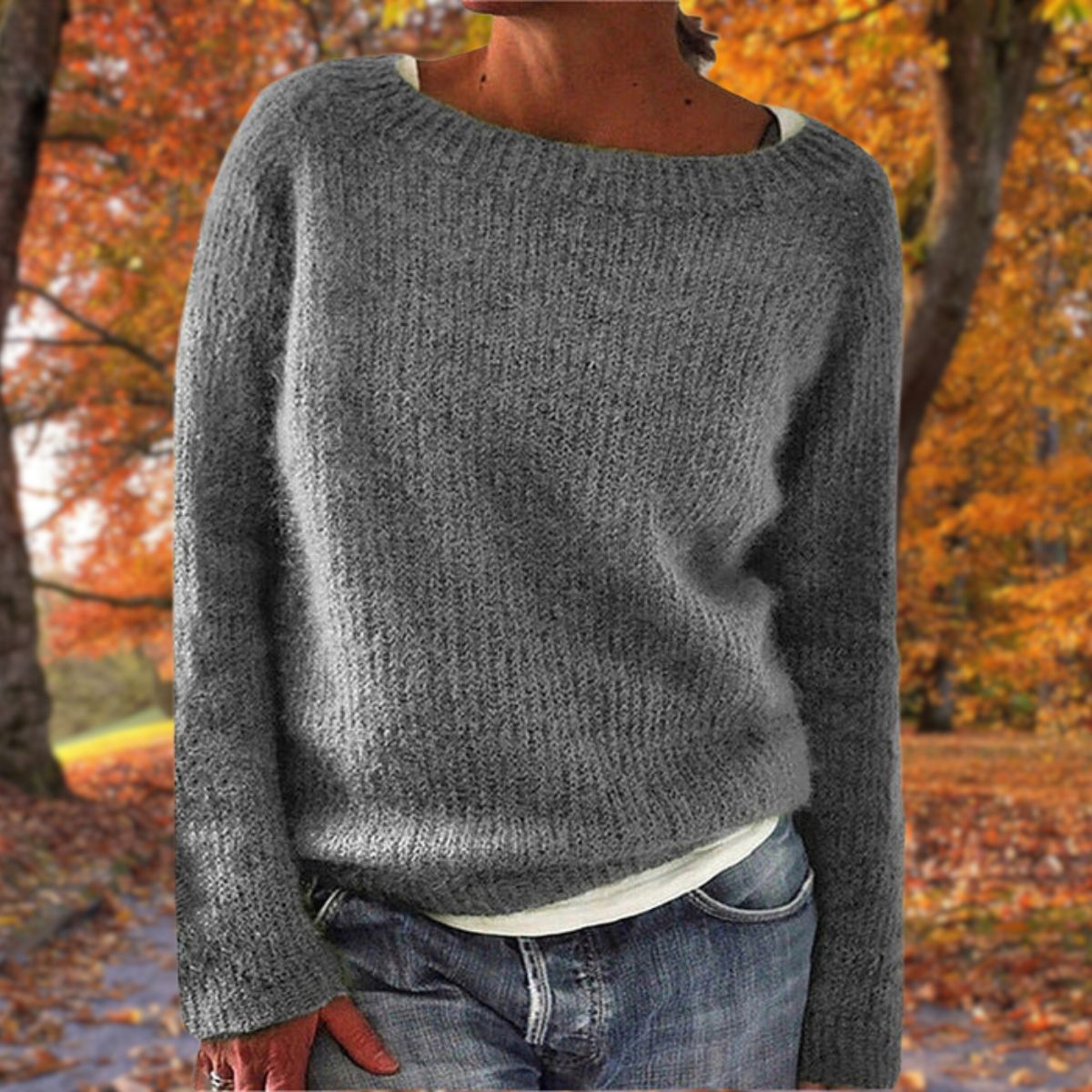 Grå striktrøje til kvinder, perfekt til efterår. Blød, varm sweater med rund hals, ideel til casual stil. Baggrund med efterårsblade.