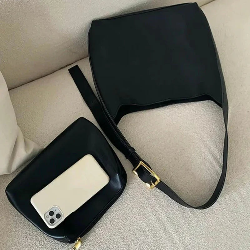 Sort lædertaske og clutch på beige sofa med smartphone. Stilfuldt tilbehør, moderne design, mode til kvinder.