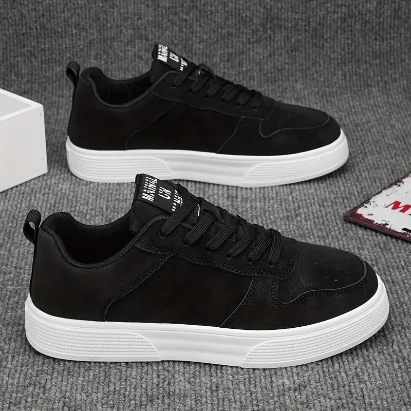 Sort sneakers med hvid sål på gråt tæppe. Moderne herresko, casual stil, komfortabelt design. Perfekt til hverdagsbrug og modebevidste mænd.