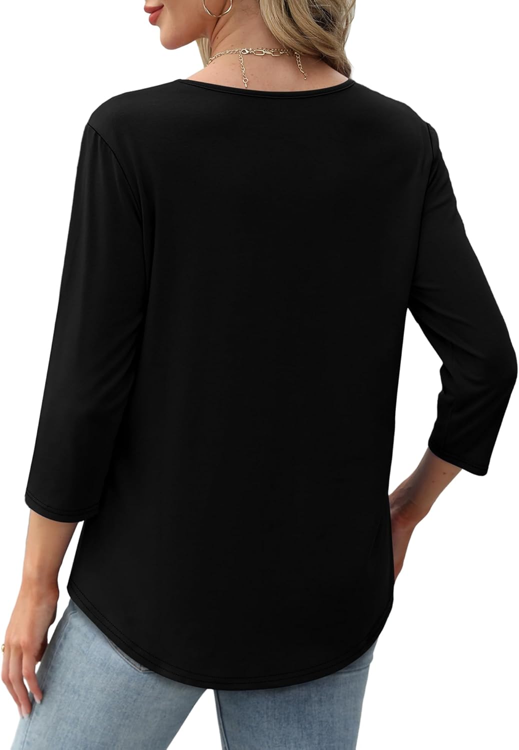 Kvinde iført sort bluse med trekvartærmer, set bagfra. Blusen er kombineret med lyseblå jeans. Mode, casual tøj, kvindelig stil.