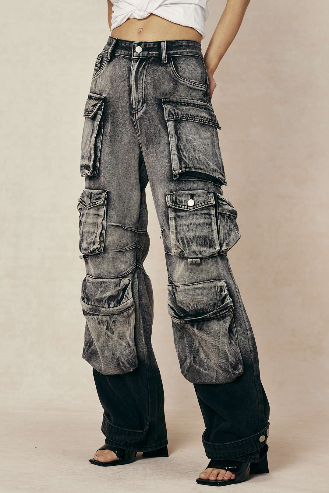 Grå cargo-bukser med mange lommer, slidte detaljer og vidde ben. Trendy streetwear-stil, perfekt til modebevidste unge.
