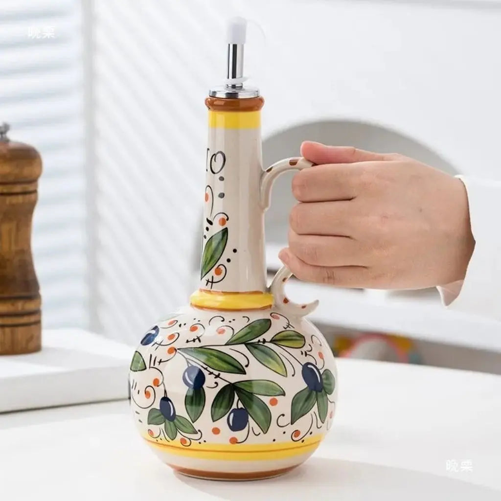 Tuscan style ceramic oil bottle featuring hand painted olive branch design with functional pour spout