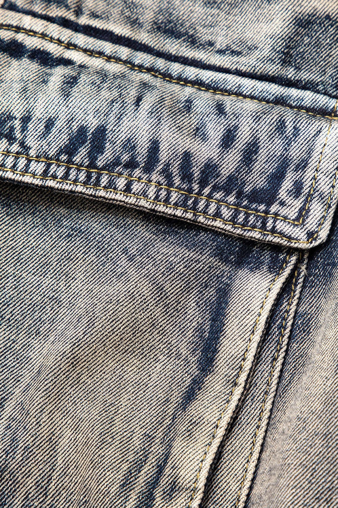 Nærbillede af blå denimstof med synlige syninger og tekstur. Perfekt til mode, jeans, tøjdesign og tekstilindustri.