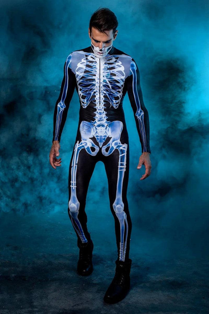 Mand i skeletdragt på blå røgfyldt baggrund, iført sort og hvidt kostume med realistisk knogleprint. Perfekt til Halloween eller kostumefest.