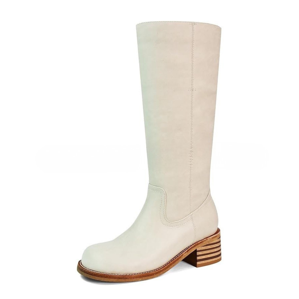 Hvid knæhøj støvle i læder med blokhæl og rund tå. Elegant design, perfekt til modebevidste kvinder. Ideel til efterår og vinter.
