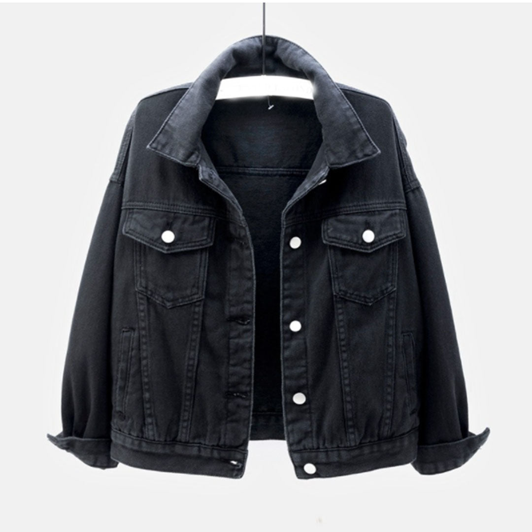 Sort denimjakke til kvinder, klassisk design med knapper og lommer, hængende på bøjle. Perfekt til casual og trendy outfits.