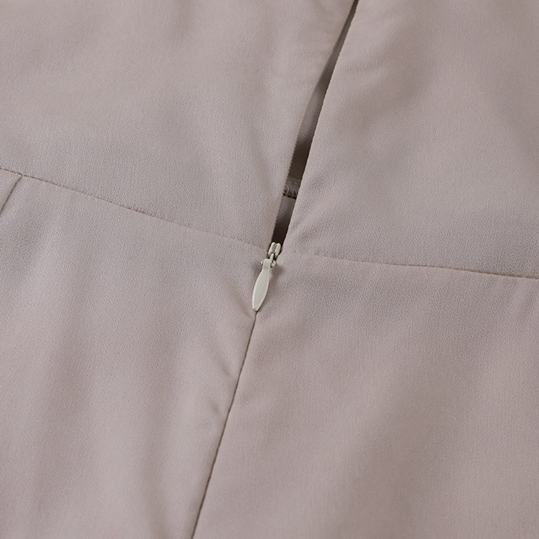 Beige kjole med lynlåsdetalje, elegant design, tæt syning, blød tekstur. Perfekt til formelle lejligheder. Høj kvalitet, moderne stil.