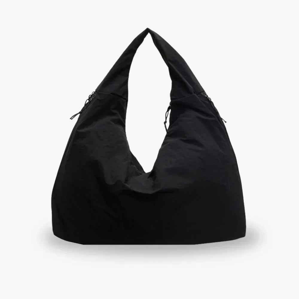 Sort hobo-taske i minimalistisk design, lavet af slidstærkt materiale. Perfekt til hverdagsbrug. Trendy og rummelig skuldertaske til kvinder.