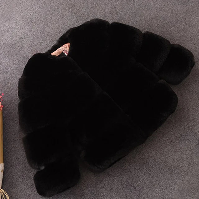 Sort pelsjakke i faux fur på grå baggrund, elegant og stilfuld vintermode til kvinder, varm og luksuriøs overtøjstrend.