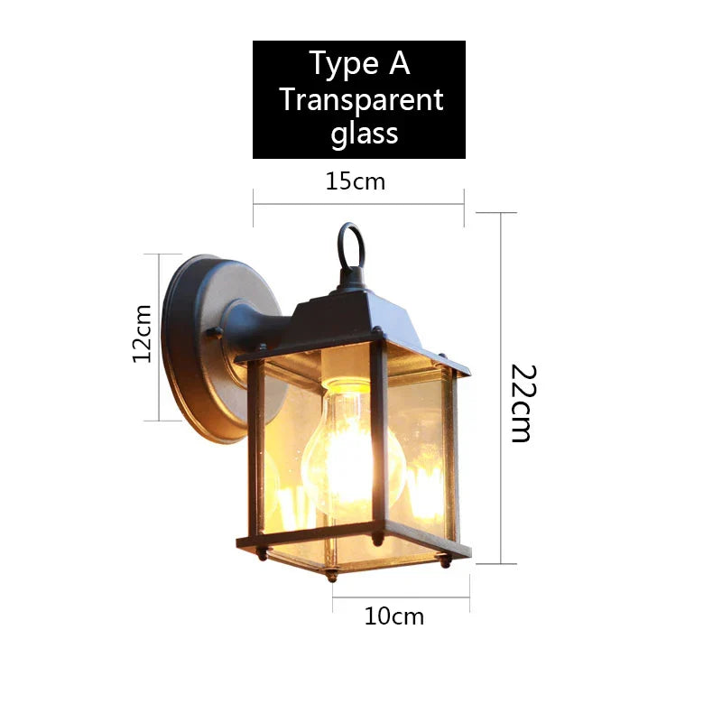 Væglampe udendørs med transparent glas, type A. Mål: 22cm høj, 15cm bred, 10cm dyb. Ideel til belysning af have og terrasse.