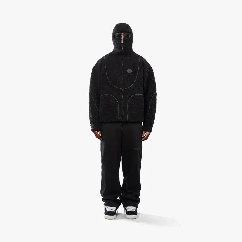 Sort hættetrøje med lynlås og hætte, bæres af person. Moderne streetwear, minimalistisk design, komfortabel pasform. Ideel til urban mode.