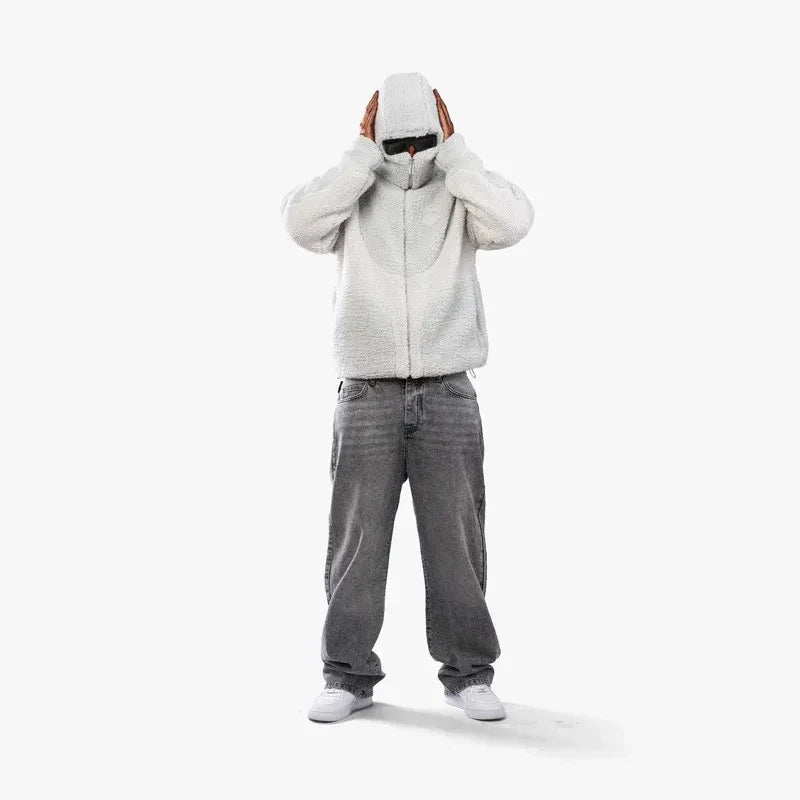 Person iført hvid hættetrøje og grå jeans på hvid baggrund. Mode, streetwear, afslappet stil, moderne tøj, unisex outfit, minimalistisk look.