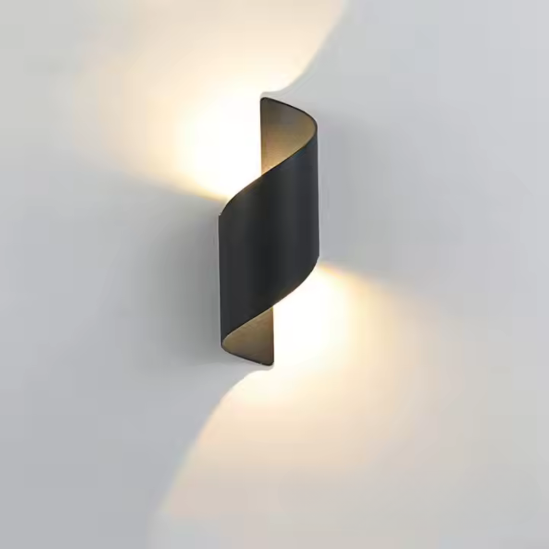 Moderne sort væglampe med snoet design, der udsender lys opad og nedad. Stilfuld belysning til stue eller soveværelse. Energi-effektiv LED.