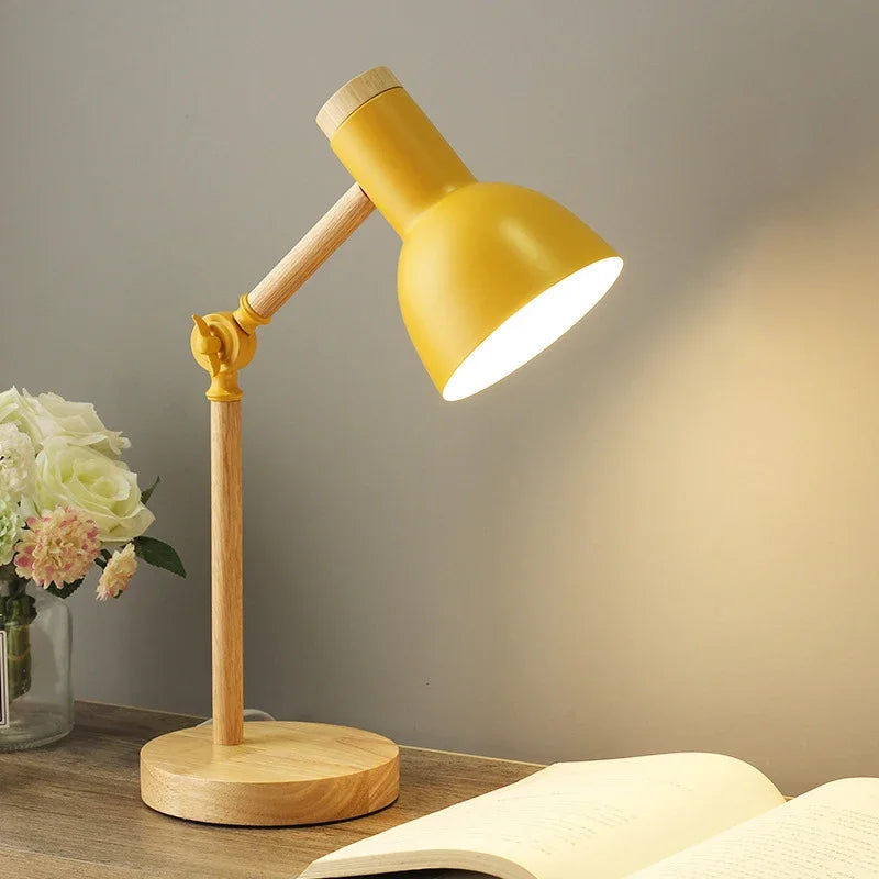 Gul skrivebordslampe i træ med justerbar arm, lyser op på en åben bog. Moderne belysning, stilfuldt design, indretning, læselampe.