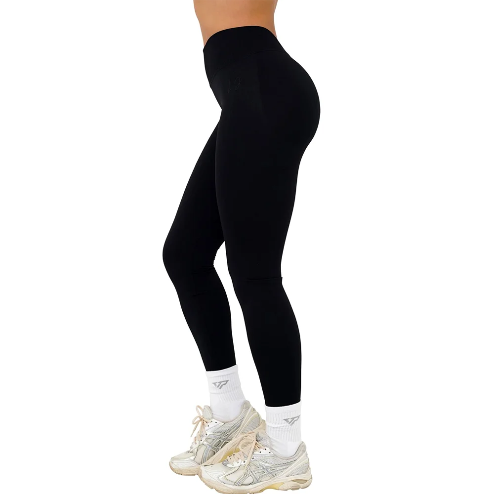 Sorte leggings til kvinder, høj talje, bæredygtigt materiale, komfortabel pasform, kombineret med hvide sneakers og sokker. Perfekt til træning.