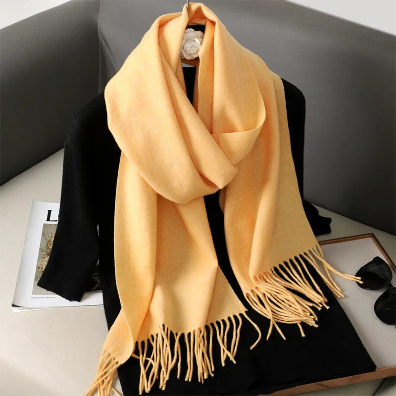 Gul cashmere tørklæde med frynser på sort baggrund, elegant og blødt tilbehør, perfekt til vintermode og stilfuld beklædning.