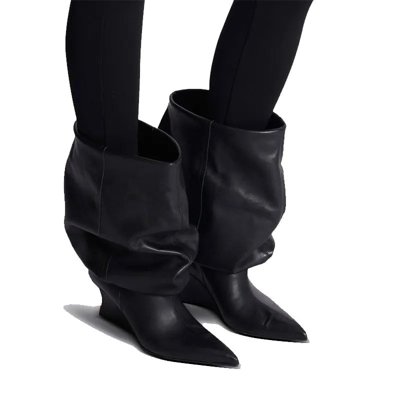 Sort læderstøvle med spids tå og slouchy design, bæres med sorte leggings. Moderne mode, stilfulde støvler, trendy fodtøj til kvinder.