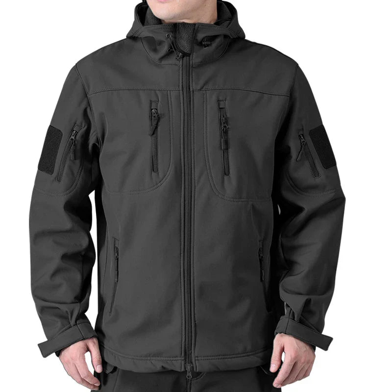 Sort softshell jakke til mænd med hætte, lynlåslommer og justerbare manchetter. Ideel til udendørs aktiviteter og friluftsliv.