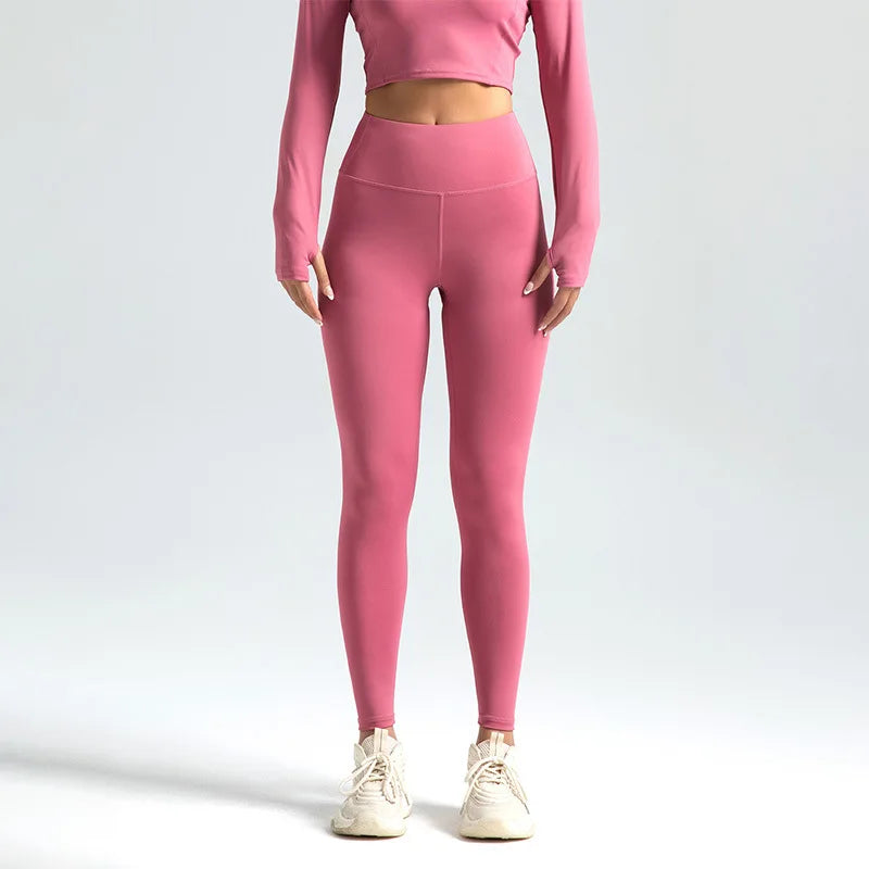 Lyserøde leggings og langærmet crop top sæt til kvinder, perfekt til fitness og yoga. Komfortabelt og stilfuldt træningstøj.