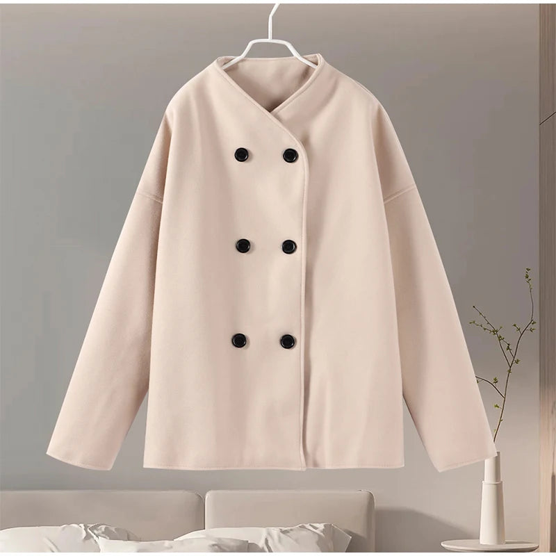 Beige dobbeltradet frakke på bøjle, minimalistisk design, sorte knapper, moderne mode, elegant overtøj til kvinder, stilfuld og tidløs jakke.