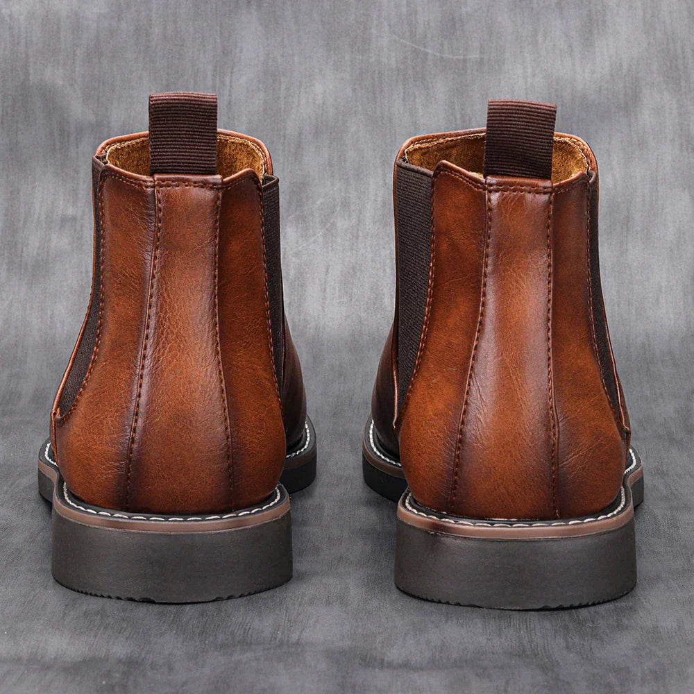 Brune læderstøvler set bagfra, med elastiske sider og robust sål. Perfekte herrestøvler til efterår og vinter. Stilfuldt fodtøj i høj kvalitet.