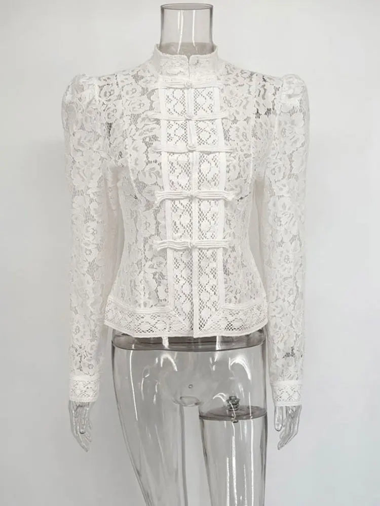 Hvid blondebluse med lange ærmer og høj hals på gennemsigtig mannequin. Elegant design, perfekt til formelle lejligheder.