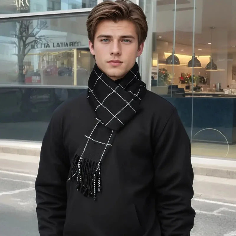Ung mand iført sort trøje og ternet halstørklæde står foran moderne bygning. Mode, vintertilbehør, stilfuldt look, bymiljø.