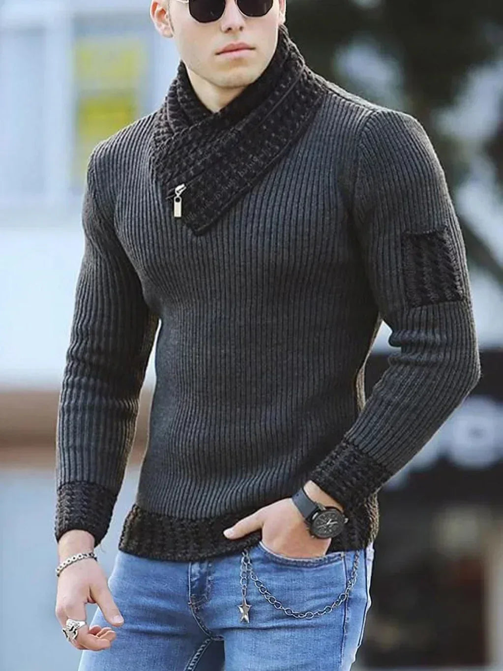 Unge mand i moderne, tætsiddende, ribstrikket trøje med lynlåsdetalje og solbriller. Casual stil med jeans og armbåndsur.
