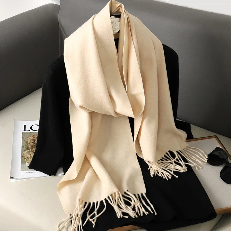 Beige cashmere tørklæde med frynser på sort baggrund, elegant og stilfuldt tilbehør, perfekt til vintermode og varme.