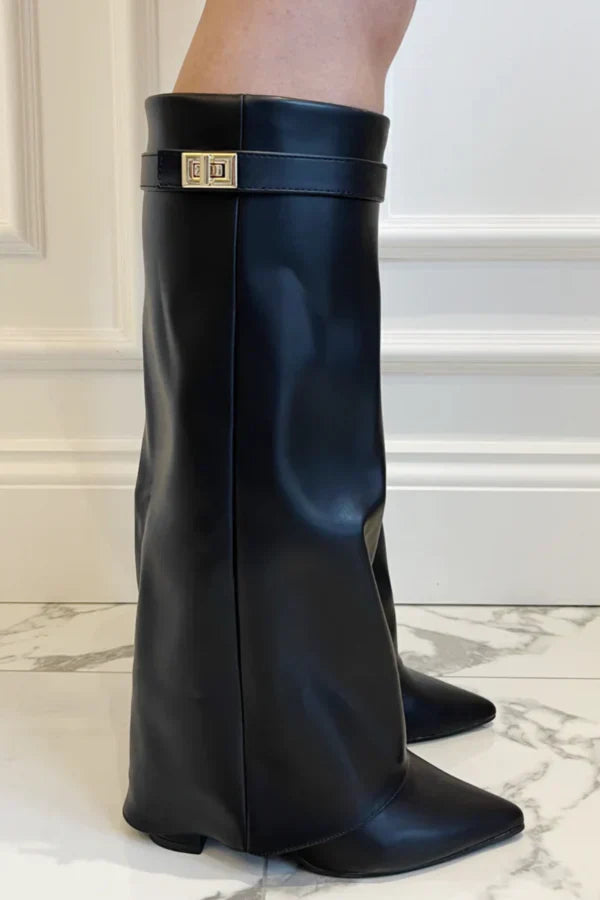 Sort læderstøvle med firkantet tå og guldspænde, stående på marmorgulv. Elegant design, perfekt til modebevidste kvinder.