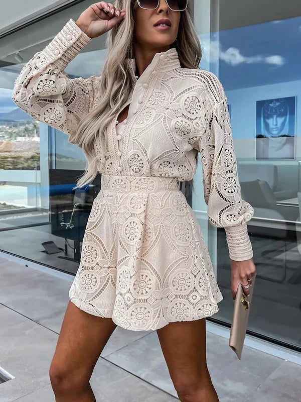 Kvinde iført elegant, beige blondekjole med lange ærmer og høj hals, poserer udendørs. Perfekt til sommermode og stilfulde begivenheder.