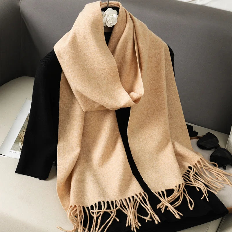Beige kashmir tørklæde med frynser på en sort sweater, elegant og stilfuldt tilbehør til vintermode. Perfekt til varme og komfort.
