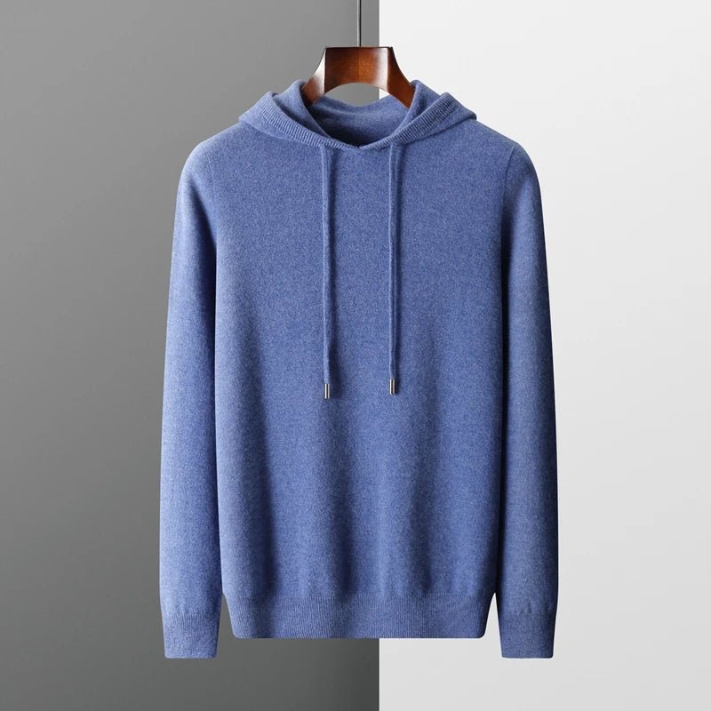 Blå hættetrøje i kashmir med snoretræk, hængende på træbøjle. Stilfuld og komfortabel sweater til mænd, perfekt til efterår og vinter.