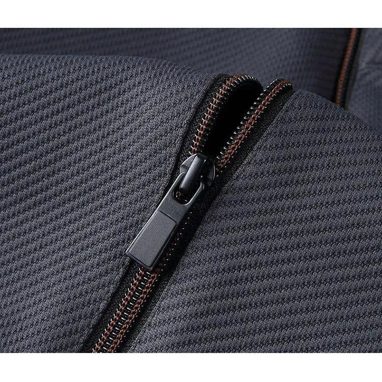 Sort lynlås på grå tekstureret stof, nærbillede. Høj kvalitet lynlås, holdbart materiale, velegnet til tasker og tøj.