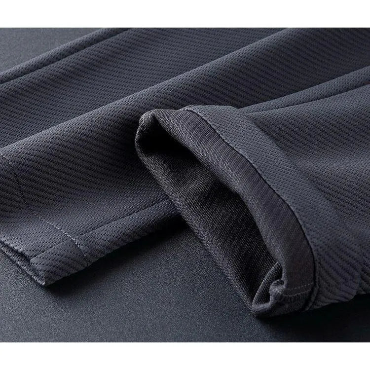 Mørkegrå sportsbukser i åndbart materiale, tæt på syning og tekstur. Perfekt til træning og fitness. Komfortabelt og stilfuldt design.