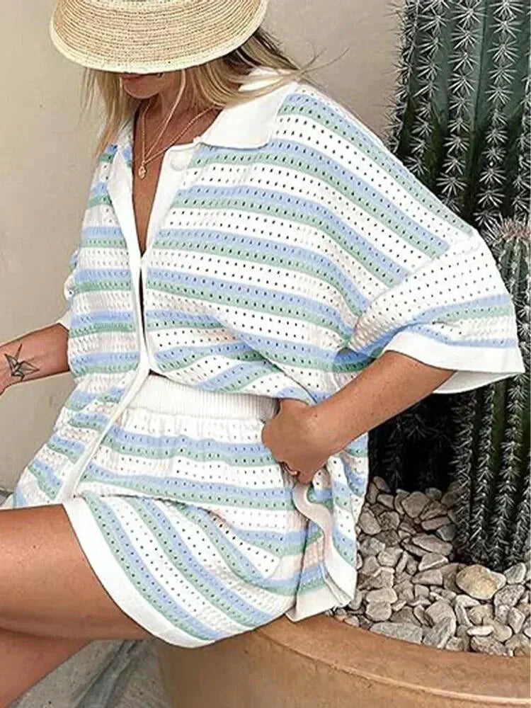 Kvinde i stribet sommeroutfit med hat sidder ved siden af kaktus. Moderne sommermode, afslappet stil, stribet tøj, udendørs.