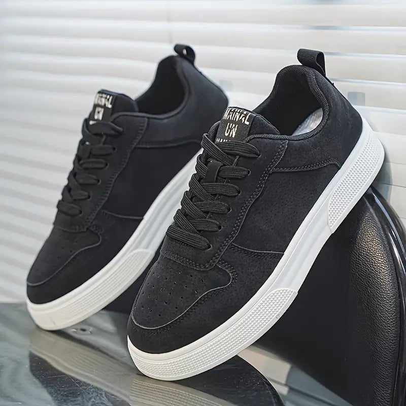 Sort sneakers med hvid sål på en stol, moderne design, snørebånd, komfortable og stilfulde sko til hverdagsbrug, herremode, casual fodtøj.