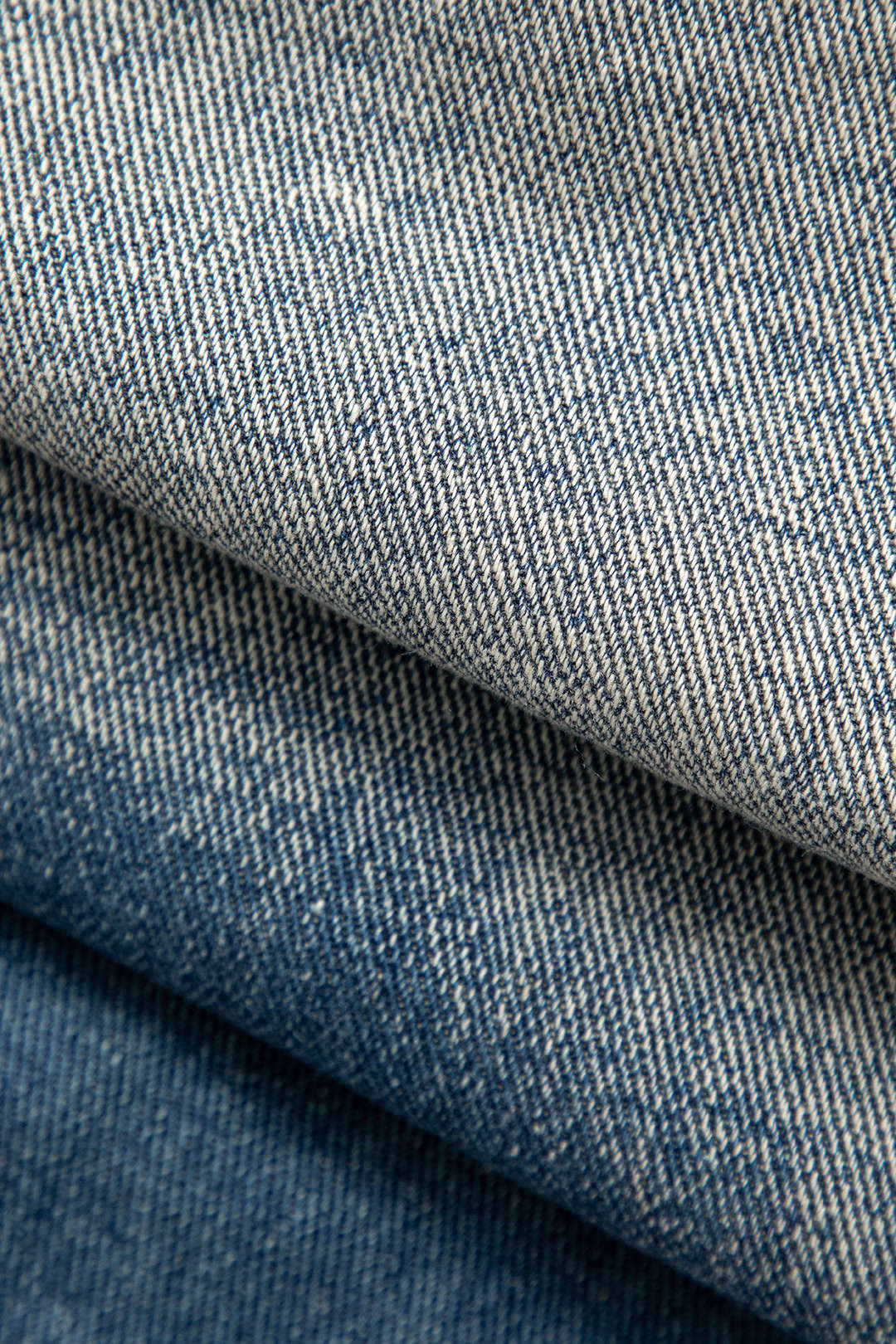 Blå denimstof i lag, tekstur og mønster, nærbillede. Perfekt til jeans, jakker og mode. Høj kvalitet, slidstærkt materiale.