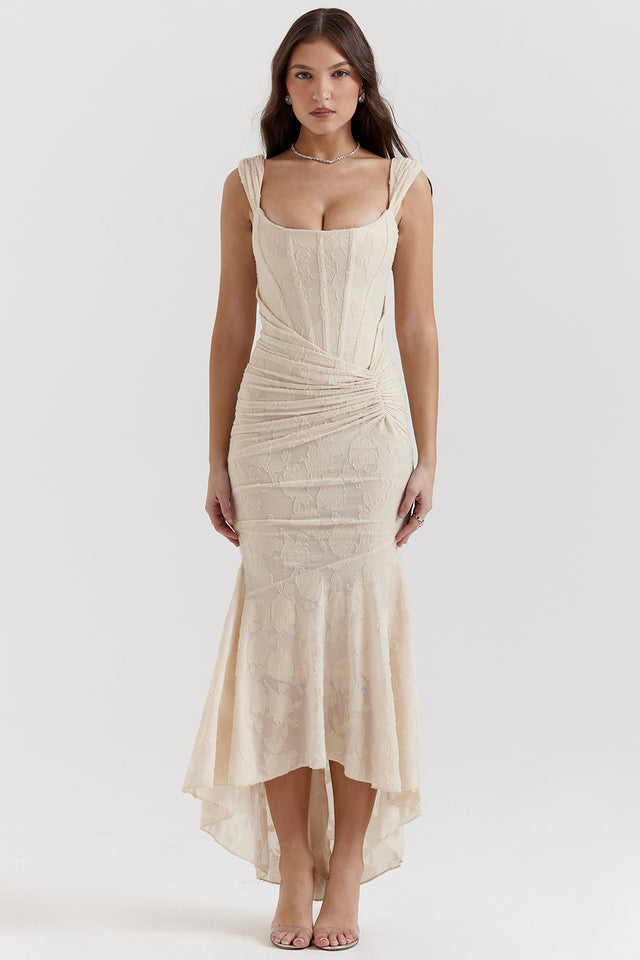 Kvinde i elegant, cremefarvet aftenkjole med blonder og asymmetrisk nederdel. Perfekt til bryllup eller fest. Mode, stilfuld, feminin kjole.