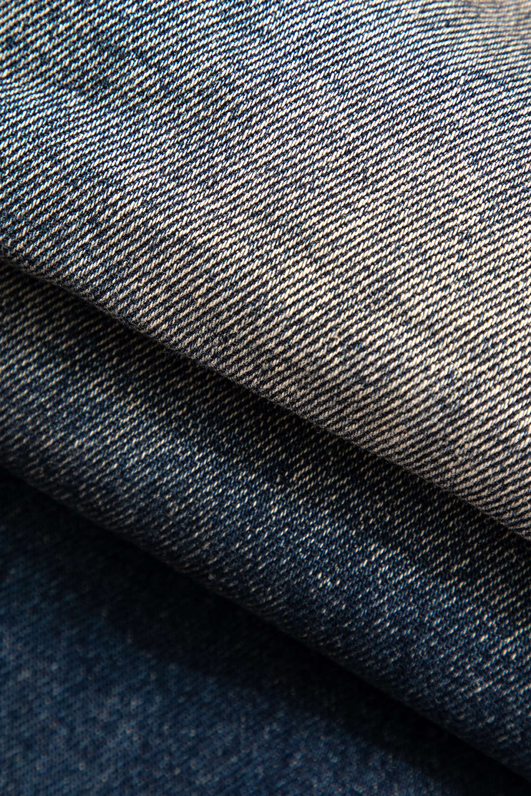 Stable denimstof i lag, tæt tekstur, blå nuancer. Perfekt til jeans, jakker, mode. Høj kvalitet, holdbart materiale, populært valg i tøjdesign.