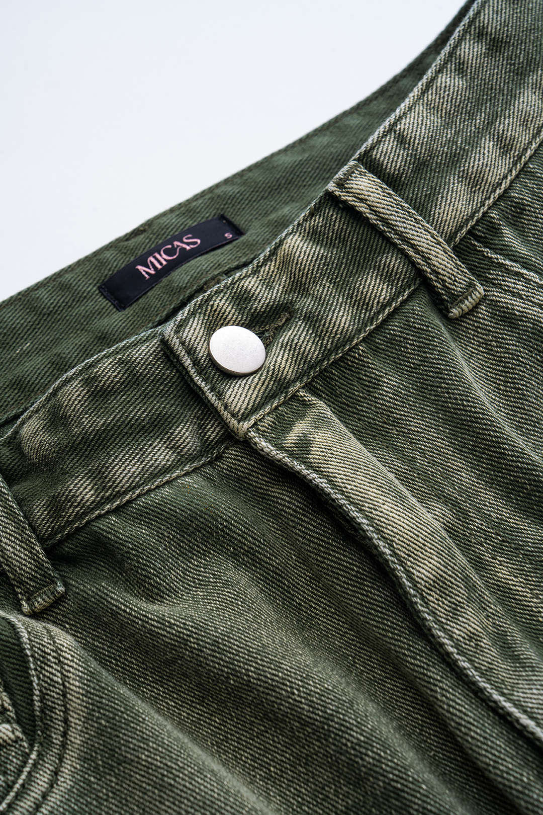 Grønne denimjeans med sølvknap og bæltestropper, mærket Micas. Moderne design, høj kvalitet, perfekt til casual og trendy outfits.