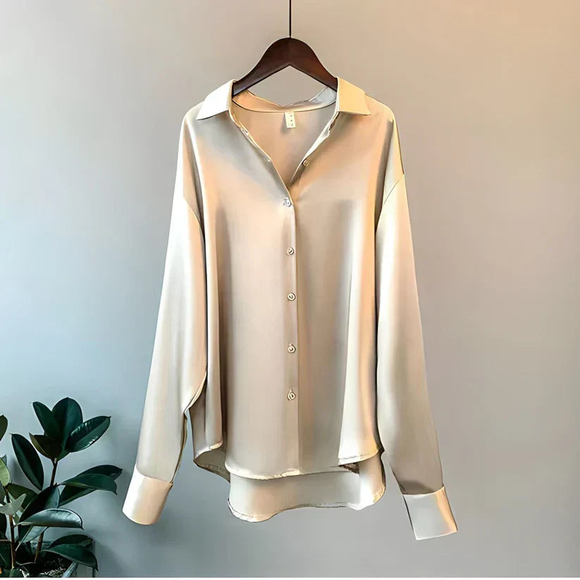 Beige silkeskjorte på bøjle, minimalistisk design, lange ærmer, klassisk krave, knaplukning, elegant og stilfuld til både hverdag og fest.