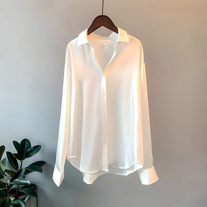 Hvid silkeskjorte på bøjle, minimalistisk design, lange ærmer, klassisk krave, knaplukning, elegant og stilfuld til både arbejde og fest.