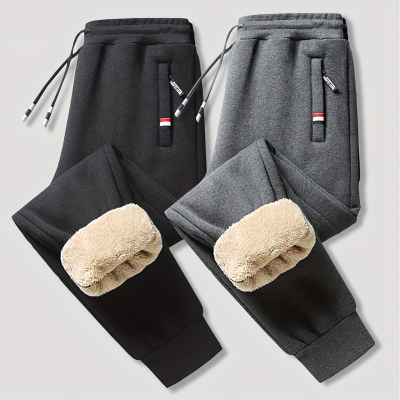 To par fleeceforede joggingbukser i sort og grå med elastisk talje og snøre. Perfekte til vinter, komfort og stil.