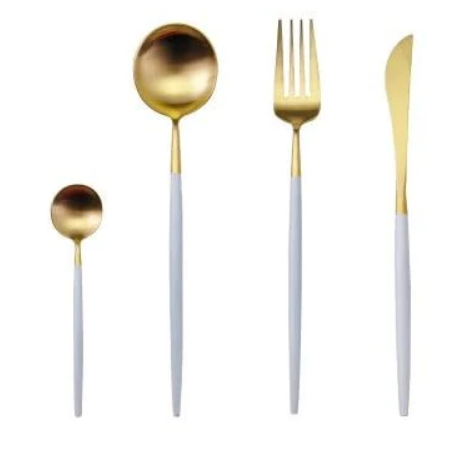 Guld- og hvidt bestiksæt med ske, gaffel og kniv. Elegant design, moderne borddækning, luksuriøst bestik til middagsselskaber.
