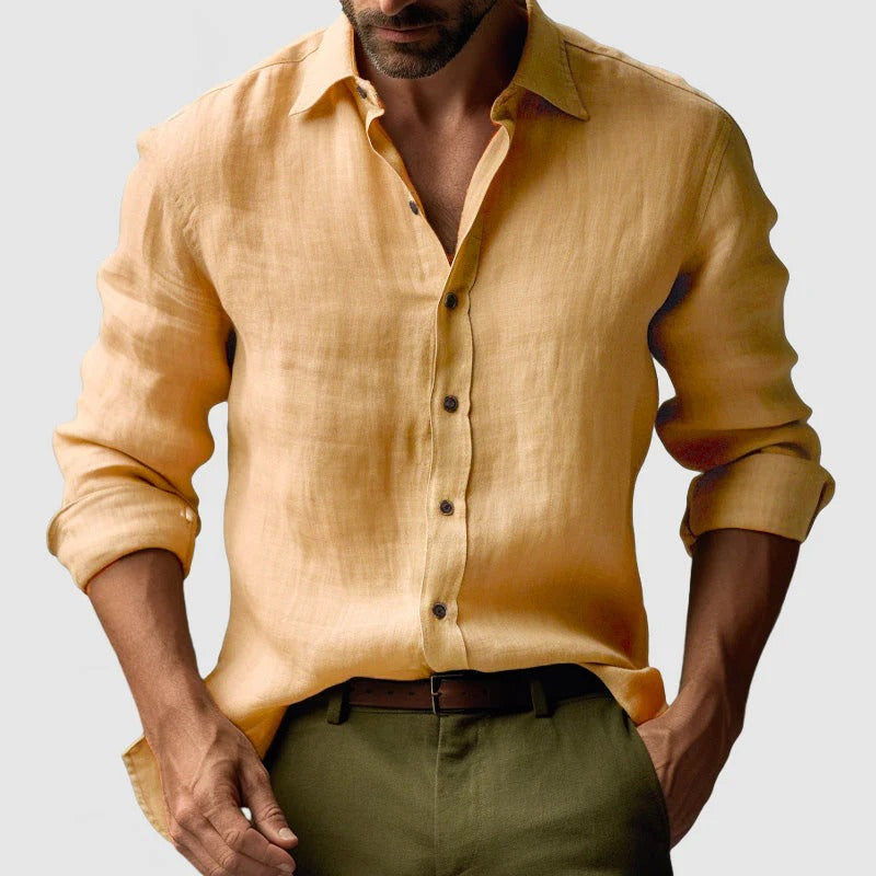 Mand iført gul hørskjorte og grønne bukser, stilfuldt afslappet look. Perfekt til sommermode, herretøj, casual stil.