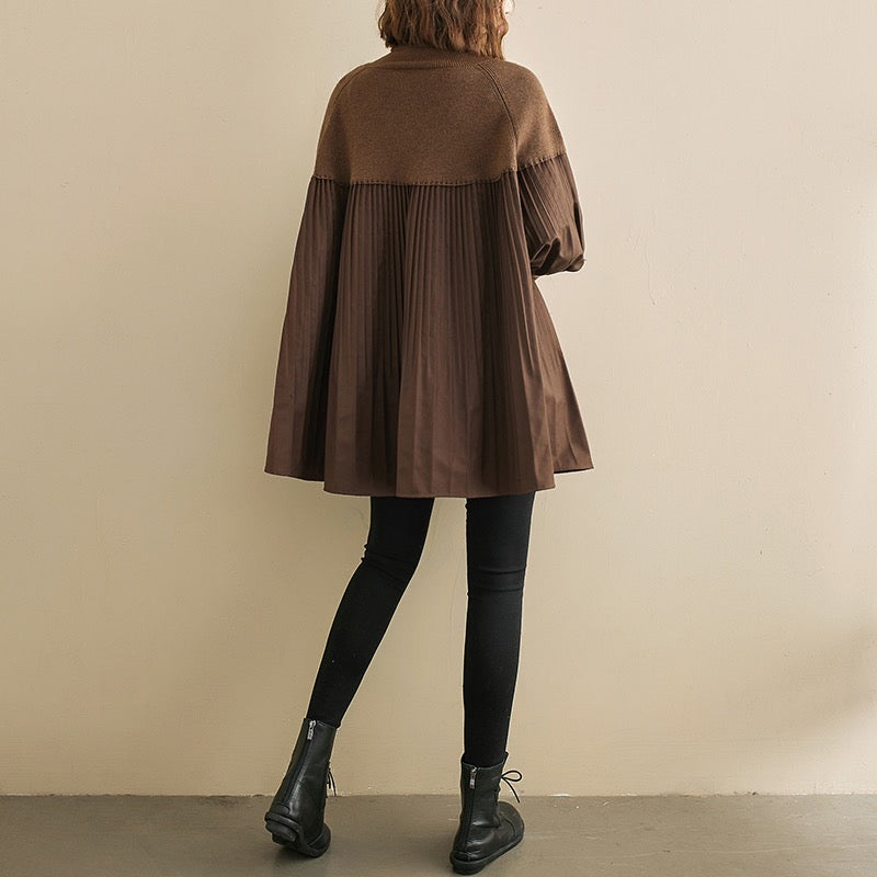 Kvinde iført brun, plisseret frakke og sorte leggings. Mode, efterårstøj, stilfuld overtøj, trendy damebeklædning, moderne design.